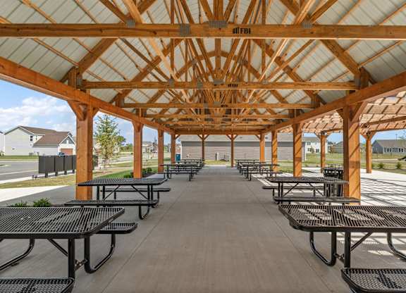 A wooden pavilion with black benches is shown.