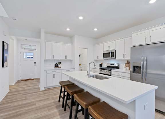 A modern kitchen with white cabinets and stainless steel appliances.