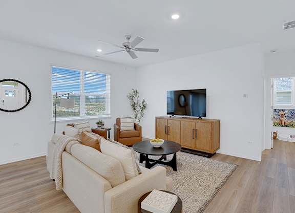 A living room with a couch, a coffee table, and a television.