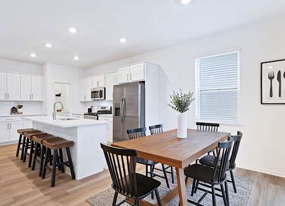 A modern kitchen with a dining table and chairs.