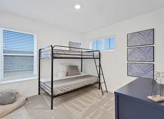 A bedroom with a bunk bed and a blue dresser.