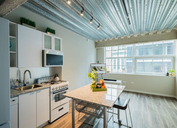 a kitchen with white appliances and a table and a window