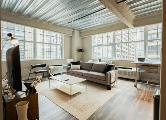 a living room with a couch and a coffee table and large windows
