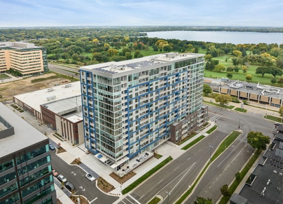an aerial view of a tall building on the corner of a city street