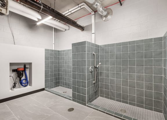 a shower in a room with gray tiles