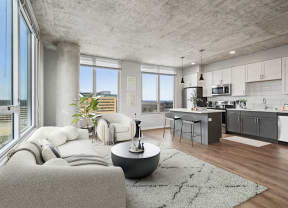 A modern living room with a grey couch and a round table.