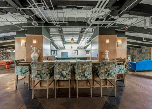 a long bar with chairs and a table in a lobby