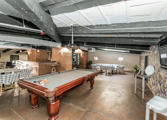 a game room with a pool table and tables