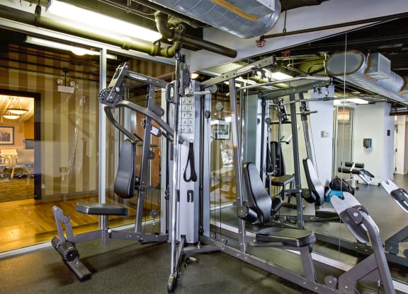 a gym with weights and cardio equipment in a building