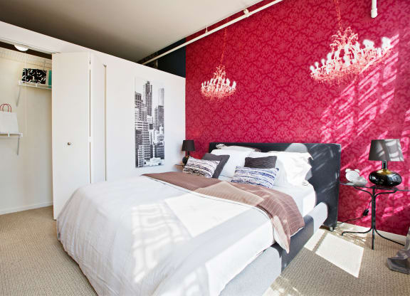 a bedroom with a red wall and a white bed