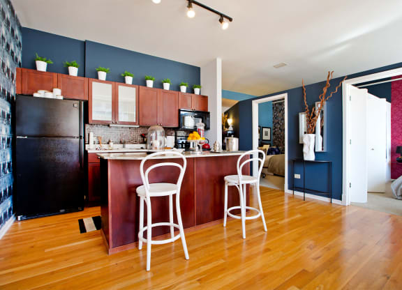 a kitchen and living room with a bar and a refrigerator