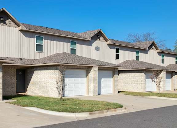 A row of houses with garages and driveways.
