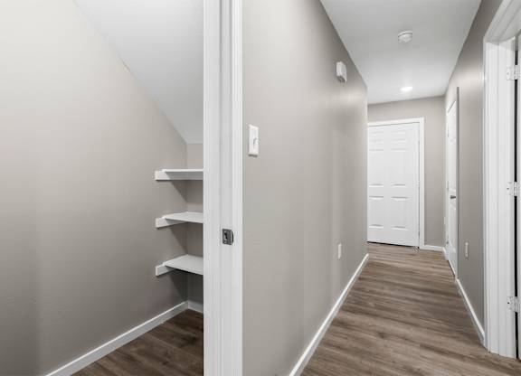 A hallway with a white door and a white light switch.