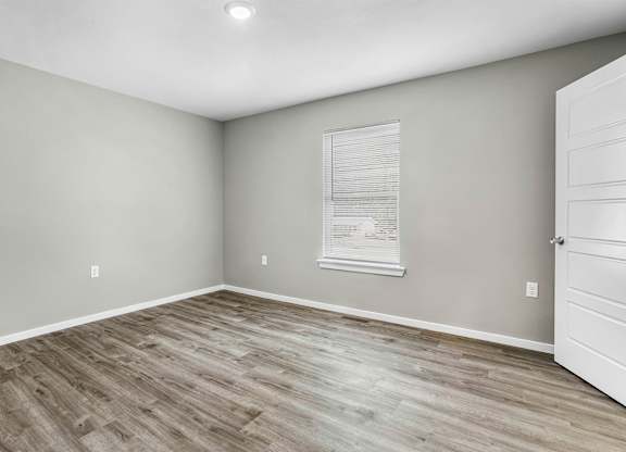 A room with wooden flooring and a white door.