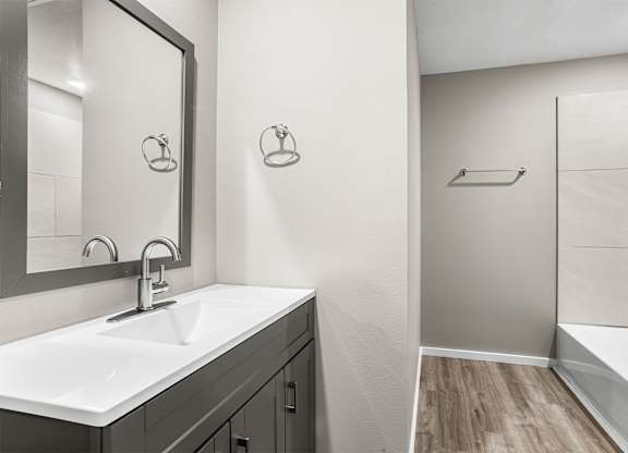 A bathroom with a white sink and a mirror.