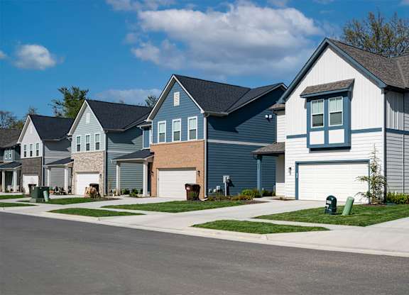 A row of houses with a blue sky in the background.