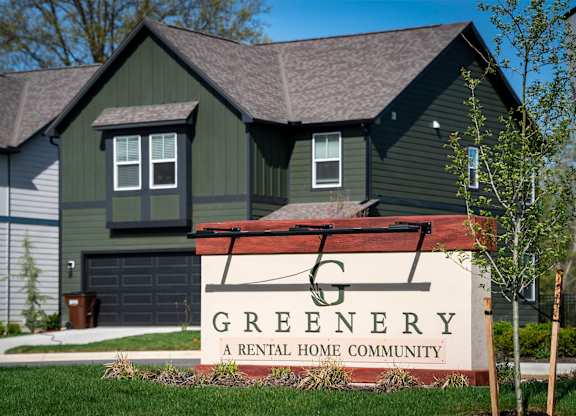 A sign that says Greenery in front of a house.