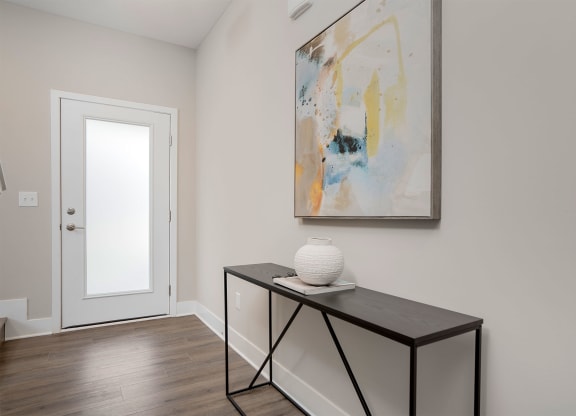 a foyer with a table and a painting on the wall