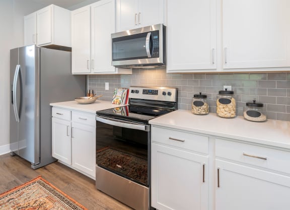a kitchen with white cabinets and stainless steel appliances