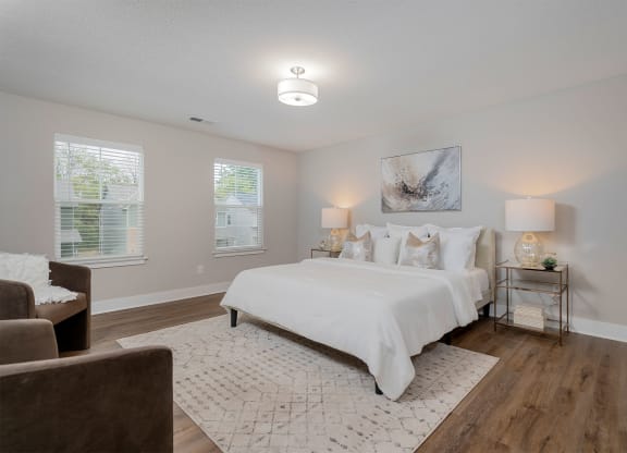 a white bedroom with a bed and a couch