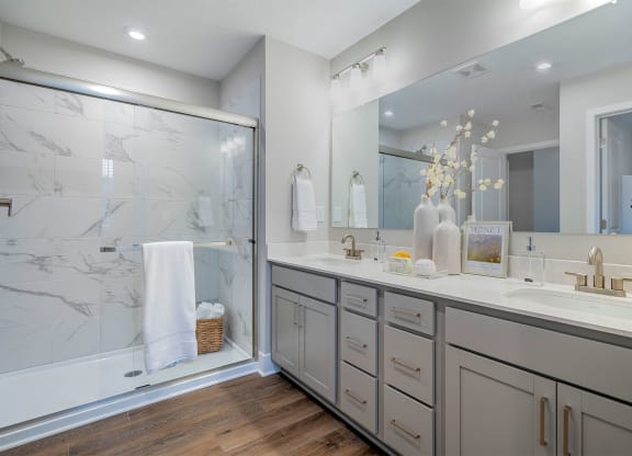 bathroom with dual vanity and standing shower