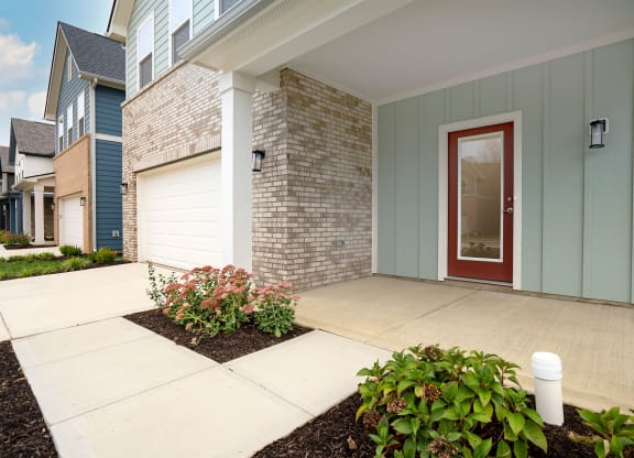 the front porch of a house with a red door