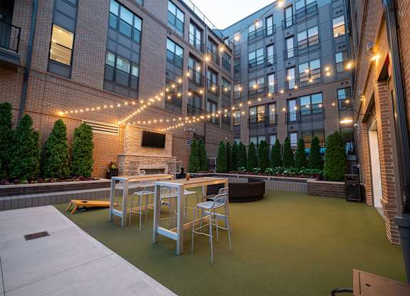 A patio with a table and chairs is surrounded by buildings.