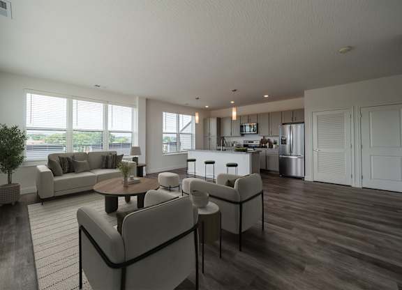 A modern living room with a grey sofa set and a wooden floor.