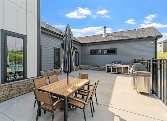 A patio with a table and chairs is set up outside a house.