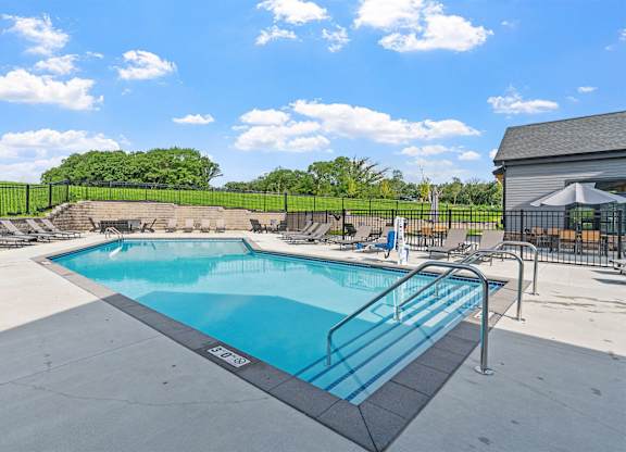 A large outdoor swimming pool with a metal railing around it.