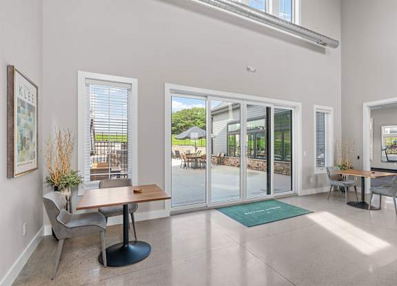 A dining room with a table and chairs and a view of the backyard through the glass doors.