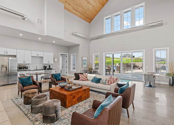 A spacious living room with a kitchen in the background.