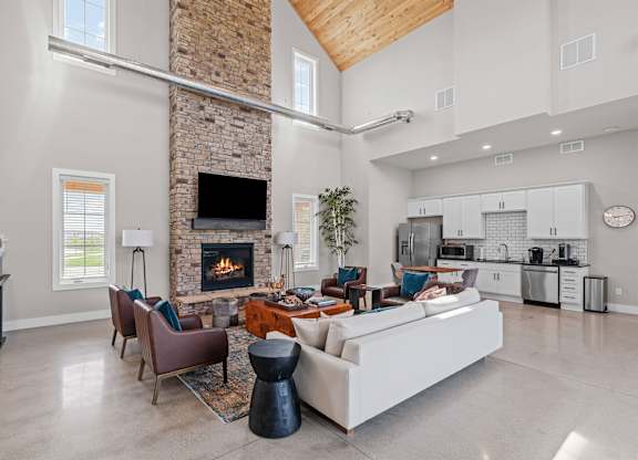 A modern living room with a stone fireplace and a large sectional sofa.