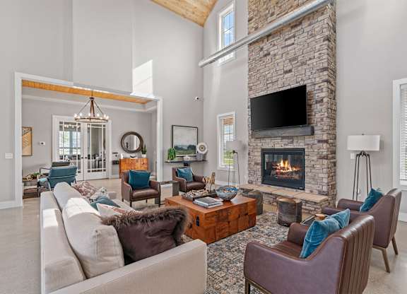 A living room with a stone fireplace and a large couch.
