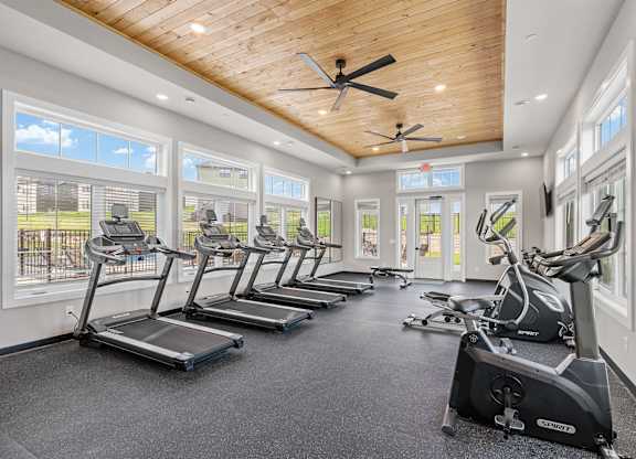 A spacious gym with treadmills and elliptical machines.