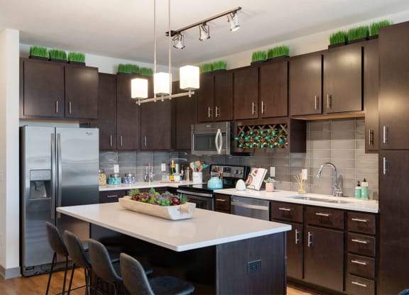 a kitchen with a large island and stainless steel appliances