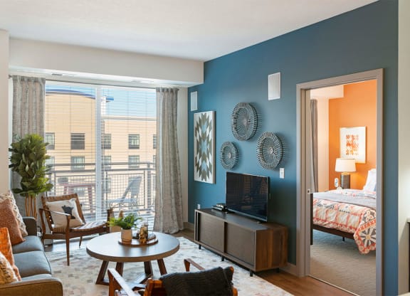 a living room with a view of a bedroom and a tv