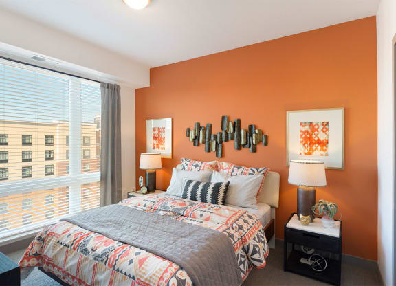 a bedroom with a bed and a large window