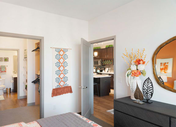 a bedroom with a bed and a mirror and a living room
