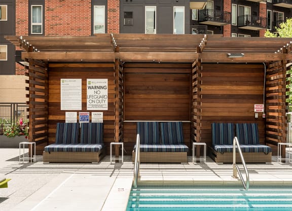 a building with a pool and chairs in front of it