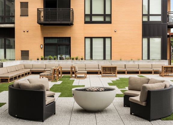 an outdoor lounge area with furniture and a fire pit