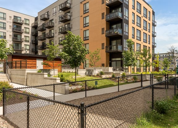 an apartment complex with a fenced in yard and a chain link fence
