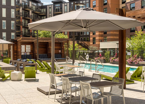 a rendering of a pool and patio with tables and umbrellas