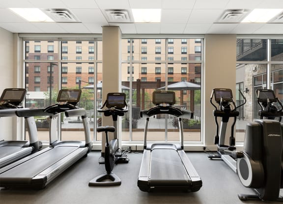 a gym with cardio machines and a view of the window