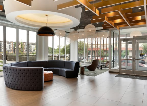 a lobby of a building with couches and glass doors