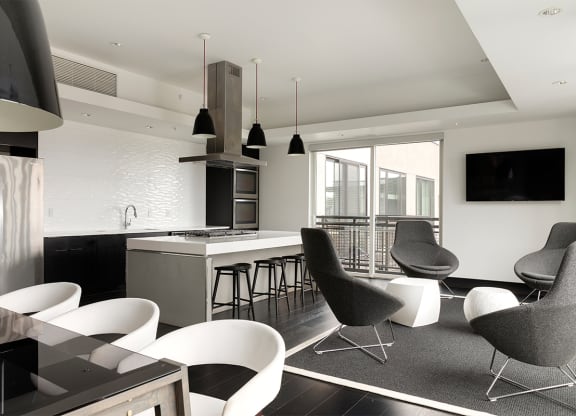 an open kitchen and living room with chairs and a bar