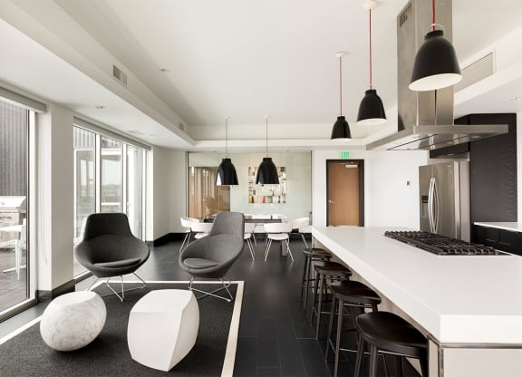 a kitchen and living room with a white counter and chairs