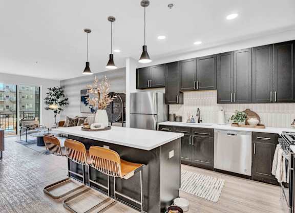 A modern kitchen with a long island and bar stools.