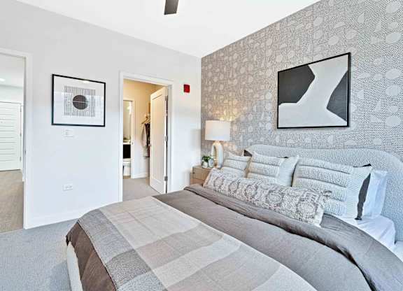 A bedroom with a large bed and a painting on the wall.