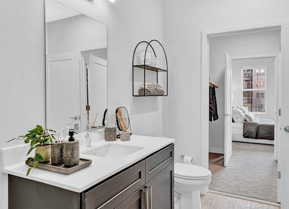 A bathroom with a white sink and a mirror above it.